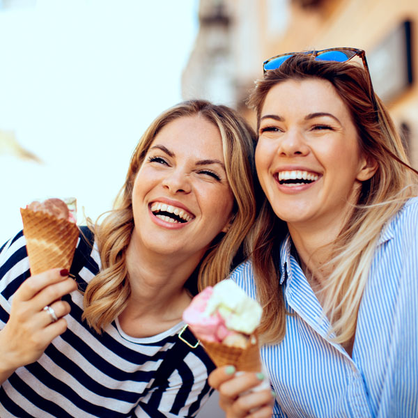 sisters enjoying ice cream and smiling